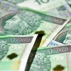 Stos stuzłotowych banknotów, idealnych na zasiłek stały. Widoczne portrety władców i nominały.