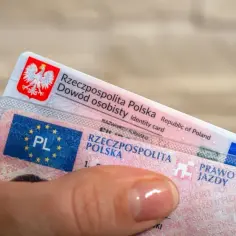 Dłoń trzyma polski dowód osobisty i prawo jazdy. Czas na wymianę prawa jazdy bezterminowego?