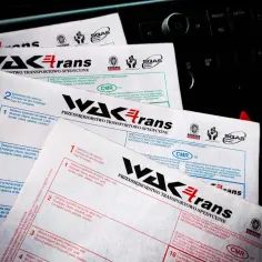 Międzynarodowe listy przewozowe CMR firmy WAKtrans leżą na desce rozdzielczej samochodu.