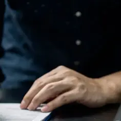 Dłoń z pieczątką nad dokumentem. Rozróżnienie między rękojmią a gwarancją jest kluczowe przy zakupach.