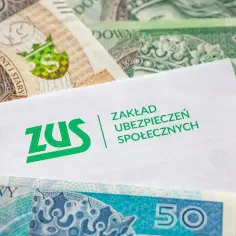 Kiedy ZUS wypłaca L4, pieniądze w postaci polskich banknotów leżą obok dokumentu z logo ZUS.