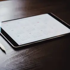 Tablet z kalendarzem i rysikiem. Zastanawiasz się, czy działalność gospodarcza wlicza się do stażu pracy? Czas to sprawdzić.