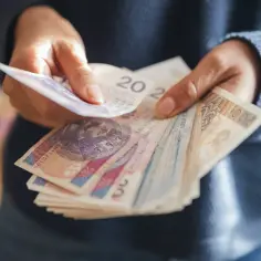 Ręce liczą banknoty. Dyskusja na forum: emerytura z OFE po 65 roku życia.