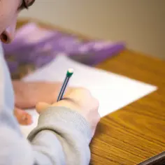 Osoba pisze na kartce, trzymając długopis. To może być część pracy twórczej, np. szkic do art. 30 kp.