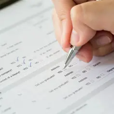 Ręka z długopisem wypełnia formularz pcc3a, zaznaczając odpowiedzi "TAK" i "NIE".