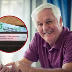 Uśmiechnięty senior z dokumentami ZUS i dowodem osobistym, korzystający z tabletu. To symbol przywilejów po 75 roku życia.