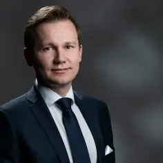 Portret mężczyzny w granatowym garniturze i krawacie.