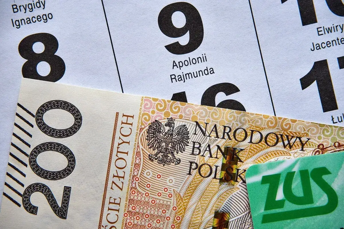 Kalendarz z datami i imionami, banknot 200 zł i karta ZUS. Termin wypłaty emerytury zależy od wielu czynników, w tym od dnia miesiąca.