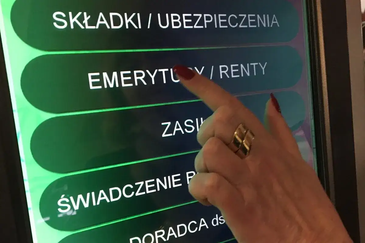 Dłoń z pierścionkiem dotyka ekranu z opcją